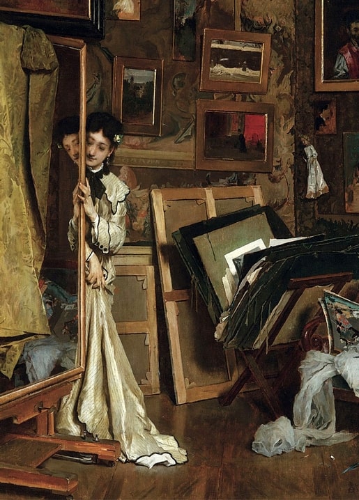 Alfred Stevens painting of a woman in ivory satin holding a framed canvas in a cluttered artist's studio