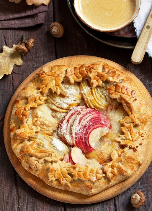Autumn food postcard featuring an apple and pear galette decorated with pastry leaves and oak leaves