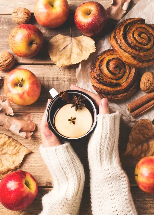 Autumn food postcard featuring apples, cinnamon pastries and a warm creamy drink on a rustic table