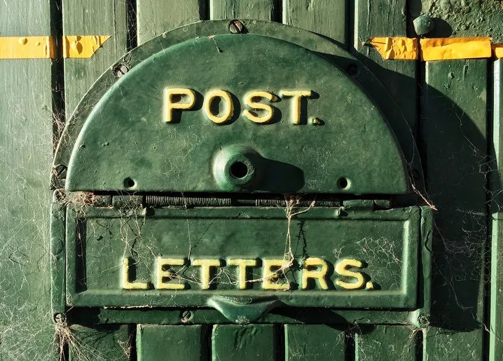 Vintage photo postcard featuring an aged green metal letterbox marked POST and LETTERS