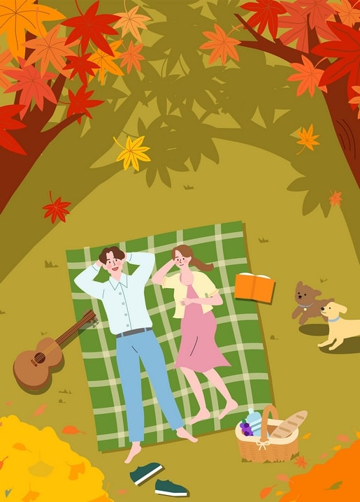 Couple lying on a plaid blanket under red maple trees with a guitar and two dogs playing nearby