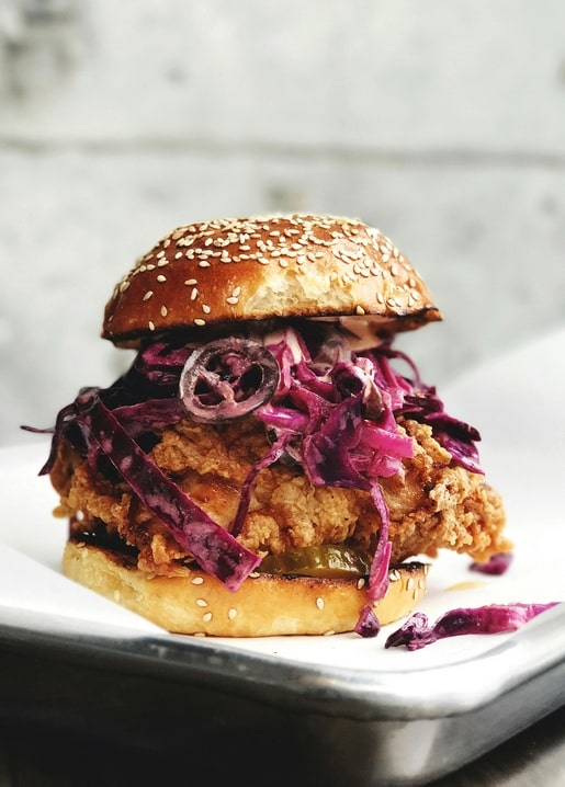 Knuspriger Hähnchen-Burger mit Rotkohlsalat auf einem Sesambrötchen