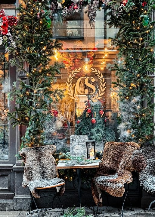 Snow-dusted café terrace with fur-covered chairs and fir garlands