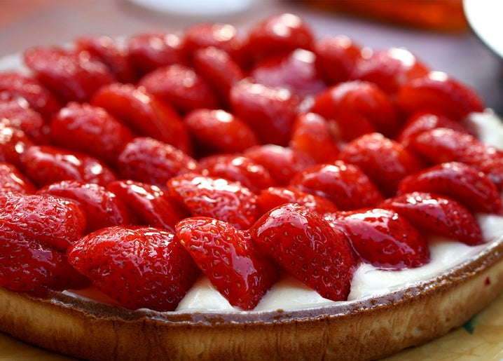 Close-up of a strawberry tart with glossy berries over creamy filling
