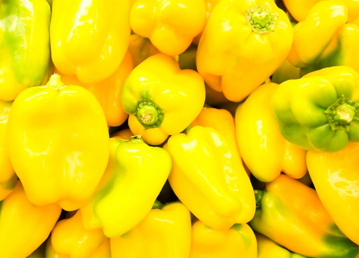 Nahaufnahme eines Haufens glänzender frischer gelber Paprika