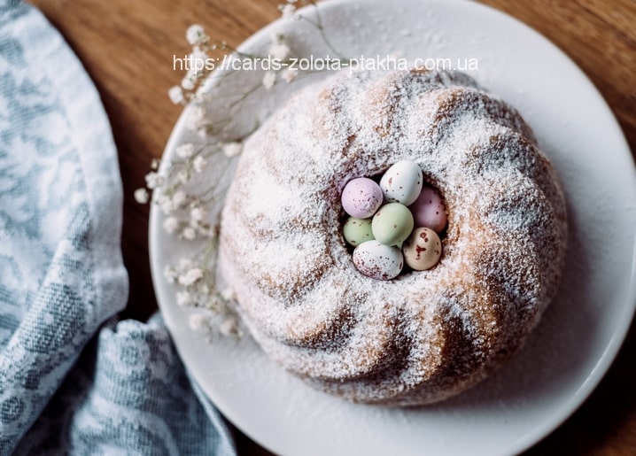 Gugelhupf mit Puderzucker und pastellfarbenen Zuckereiern