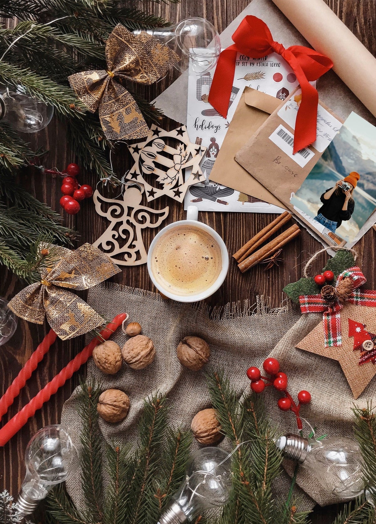 Christmas flat lay with coffee, pine branches, cinnamon sticks, and tied holiday mail