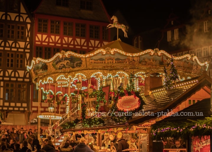 Beleuchtetes Karussell mit goldenem Pferd auf einem nächtlichen Weihnachtsmarkt