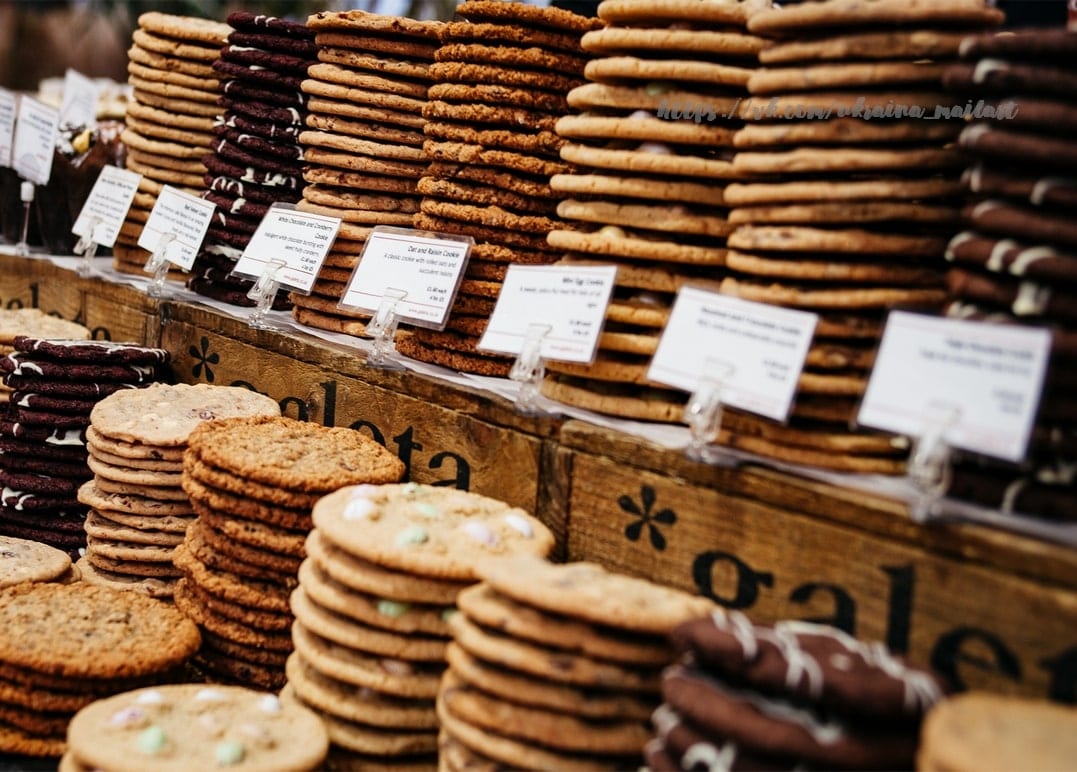 Kekse in Stapeln an einem Marktstand mit handbeschrifteten Schildern