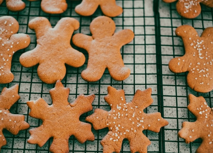 Lebkuchenmänner und Schneeflocken-Kekse kühlen auf einem Gitter ab