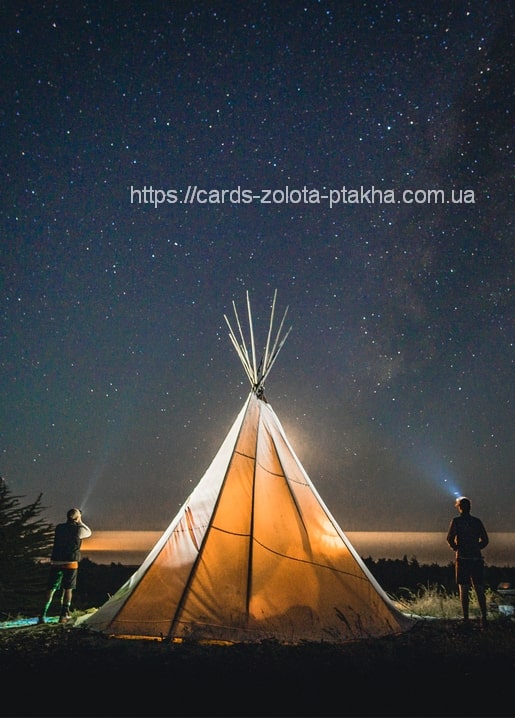 Beleuchtetes Tipi leuchtet unter Sternenhimmel und Milchstraße bei Nacht