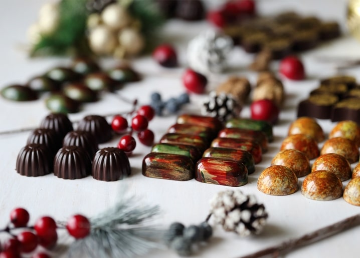 Handgemachte Pralinen-Auswahl mit Tannenzapfen und Cranberrys