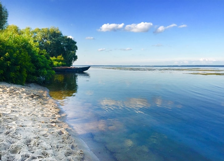 Дерев'яний човен на піщаному березі Канівського водосховища влітку