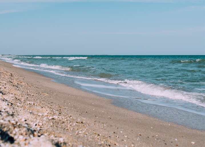 Sandy beach with turquoise waves in Kyrylivka, Ukraine