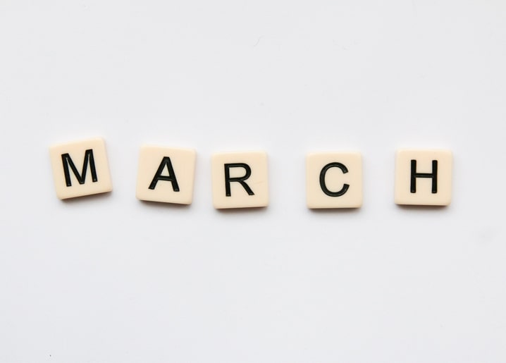 Кремові кубики-літери складають слово MARCH на білому тлі