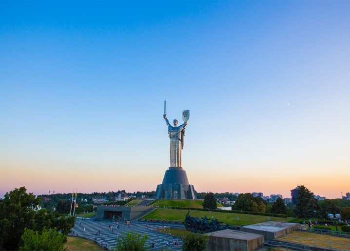 Монумент «Батьківщина-мати» в Києві на тлі вечірнього неба з молодим місяцем