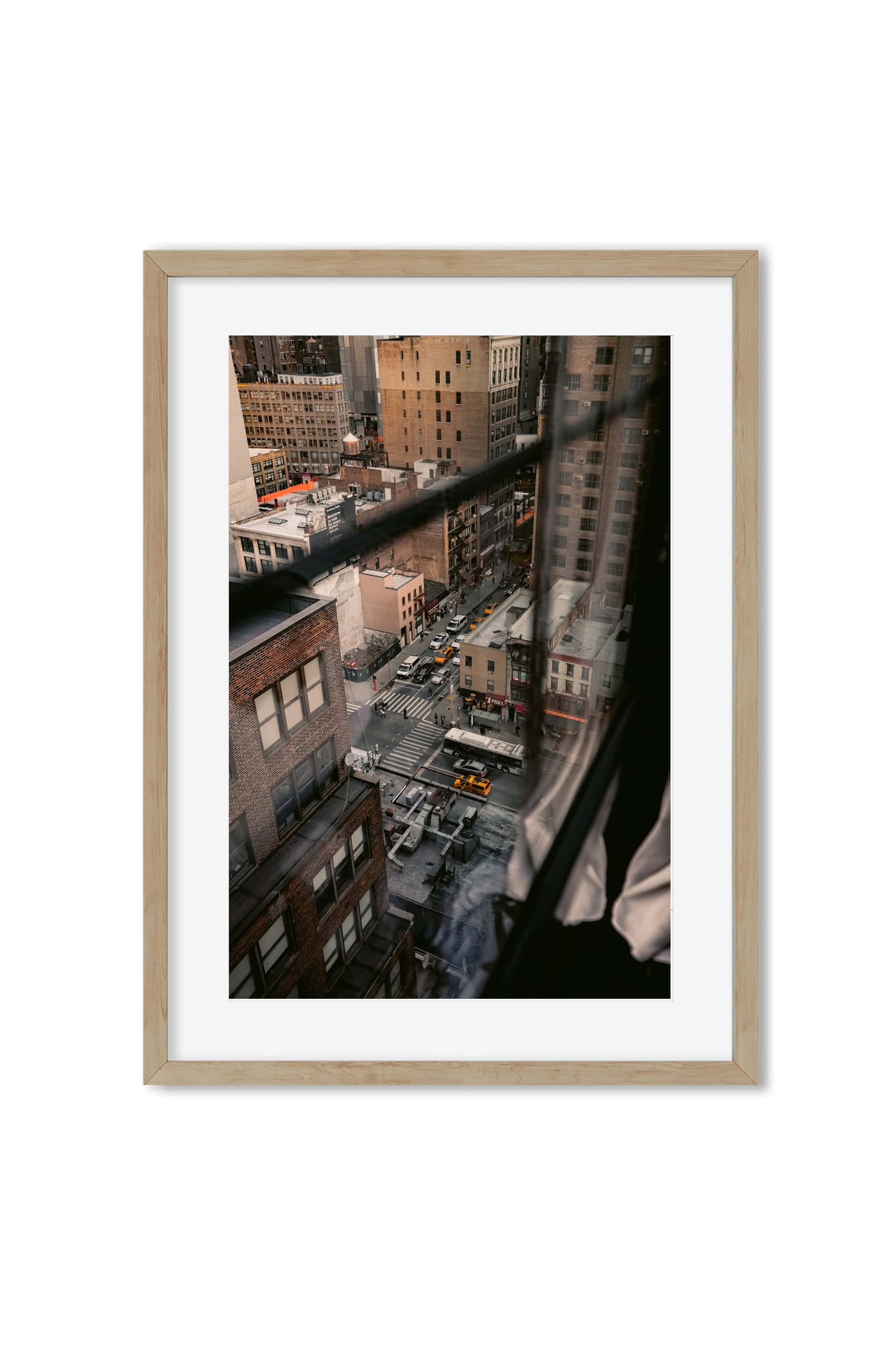 View of a Manhattan street with a yellow cab, seen through a window with a sheer curtain