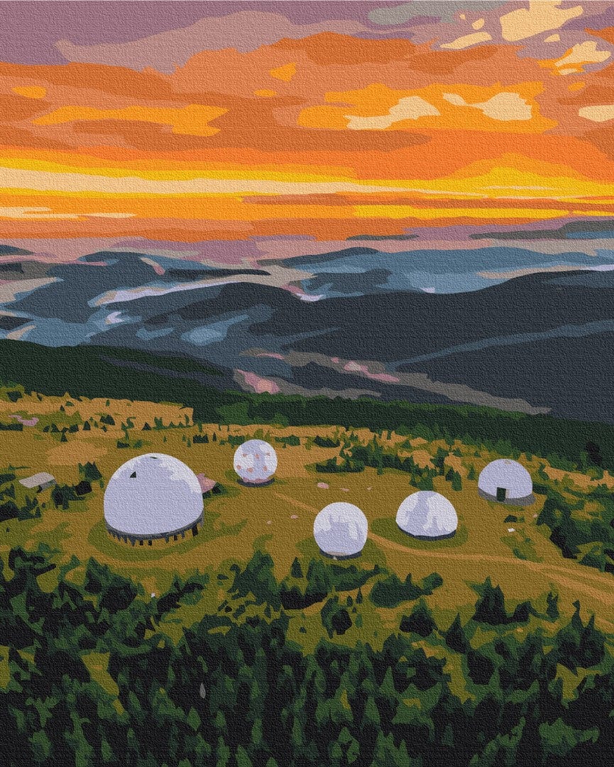 Weiße Radarkuppeln auf einem Hügel unter orangefarbenem Morgenhimmel