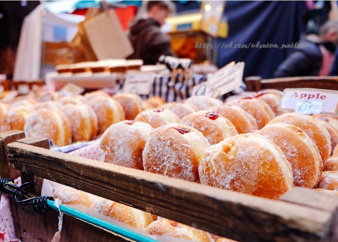 Puderzucker-Krapfen mit Marmelade in einer Holzkiste auf dem Marktstand