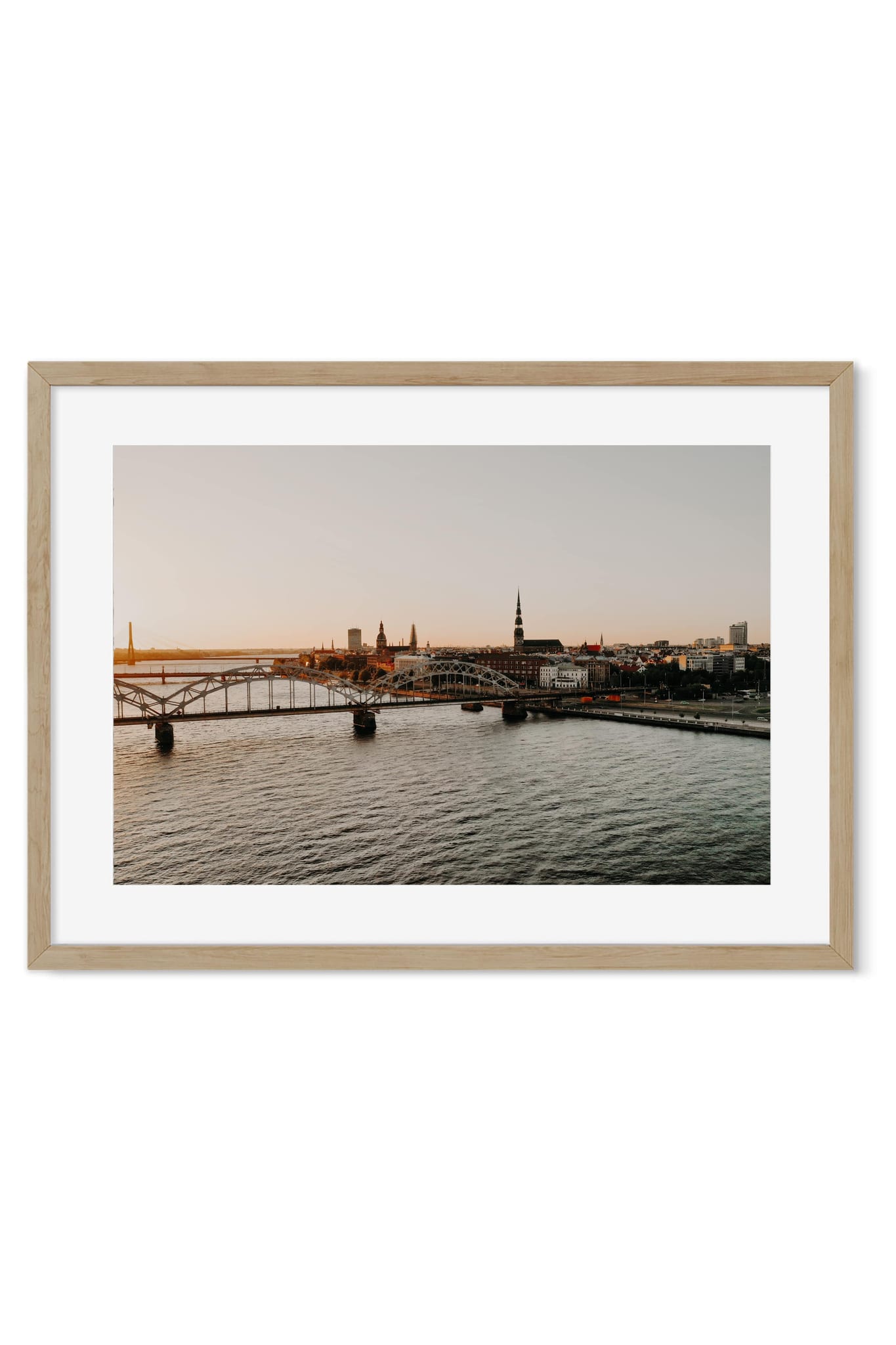 Sunset cityscape with an old bridge crossing the river and church spires in the distance