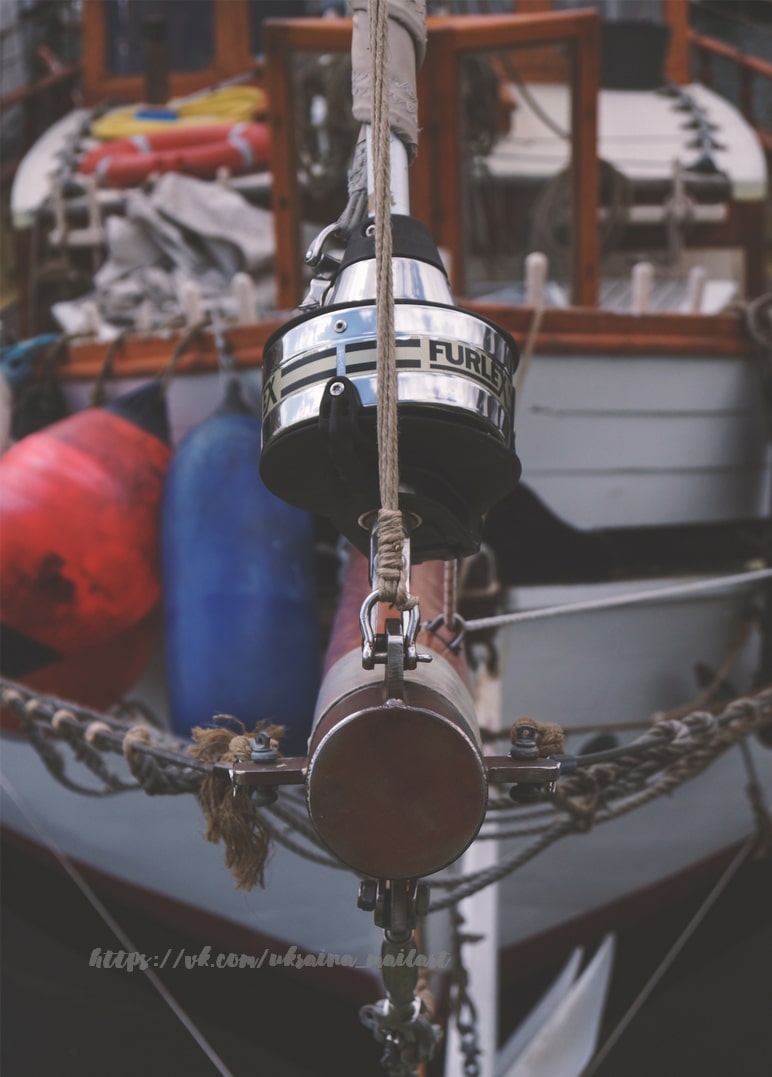 Rollreff-Trommel und Tauwerk eines Segelboots in Nahaufnahme mit Fendern im Hintergrund