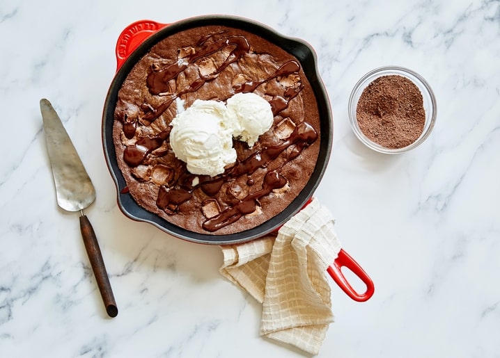 Gusseisenpfannen-Brownie mit Vanilleeis, Schokoladensauce und Kakaopulver