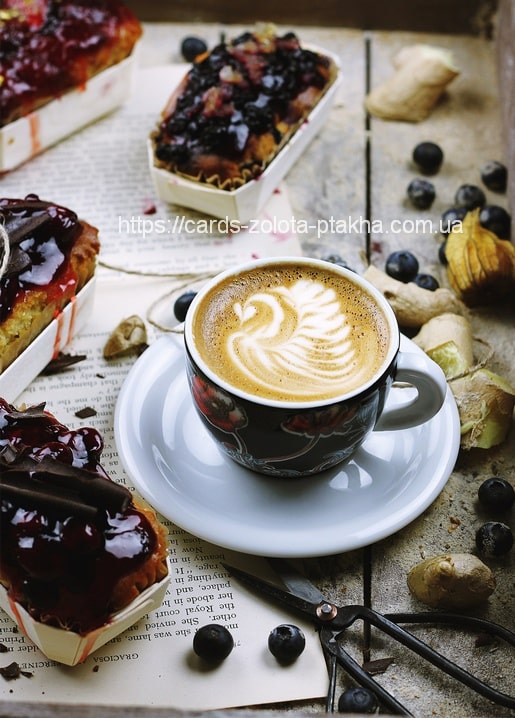 Latte-Art-Schwan neben Heidelbeergebäck, Ingwer und einer Vintage-Schere