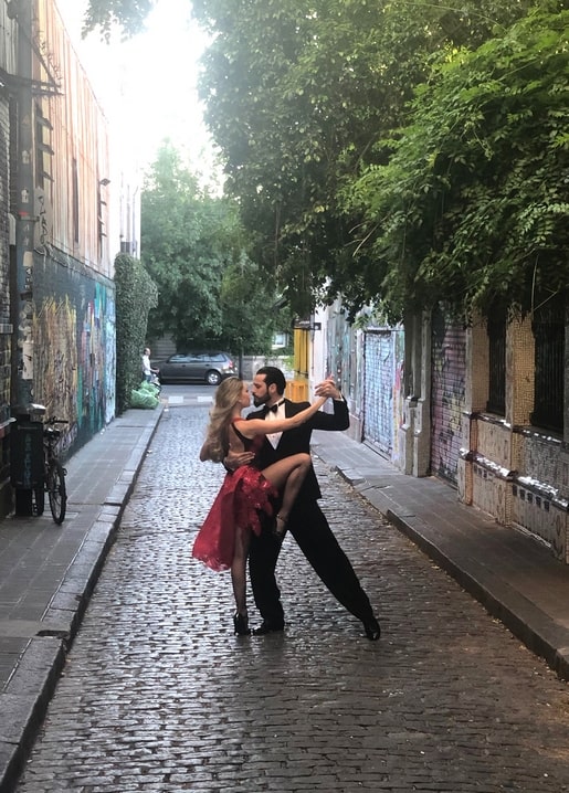 Paar in einer Tango-Dip-Figur auf einer Kopfsteinpflaster-Gasse mit Graffiti