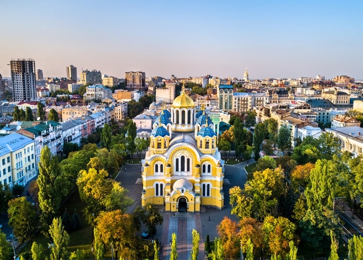 Вид з висоти на золоті та сині бані собору Святого Володимира серед осінніх дерев у Києві