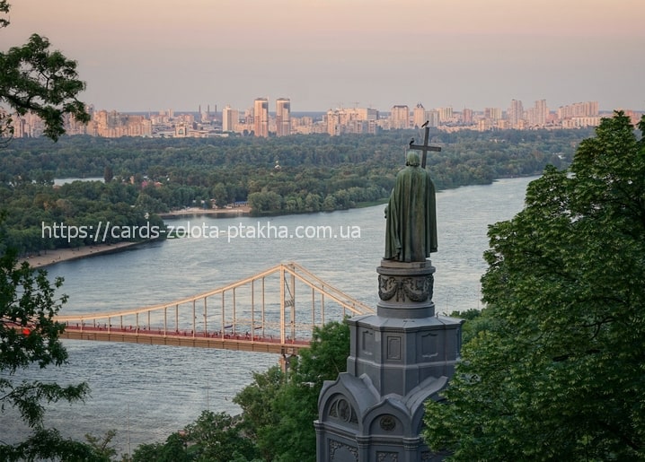 Statue of Volodymyr the Great overlooking the Dnipro River and Kyiv skyline at dusk