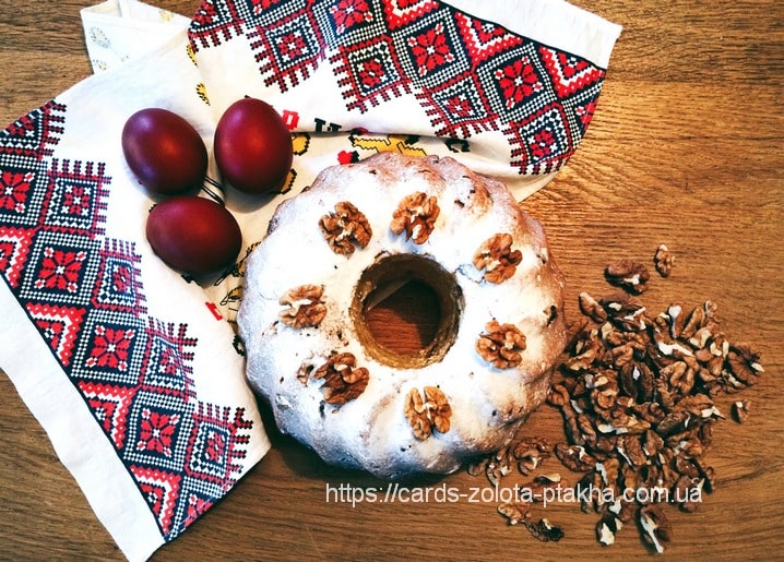 Walnusskranz und rote Ostereier auf einem bestickten ukrainischen Rushnyk