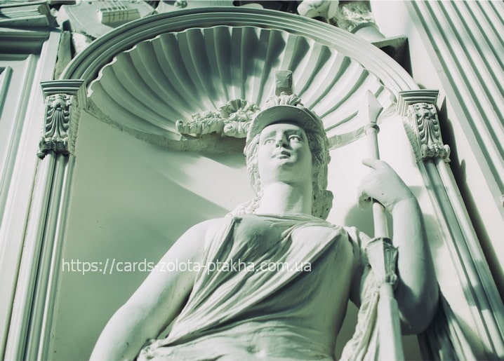 Greenish statue of a helmeted goddess with a spear in a shell niche with Corinthian columns