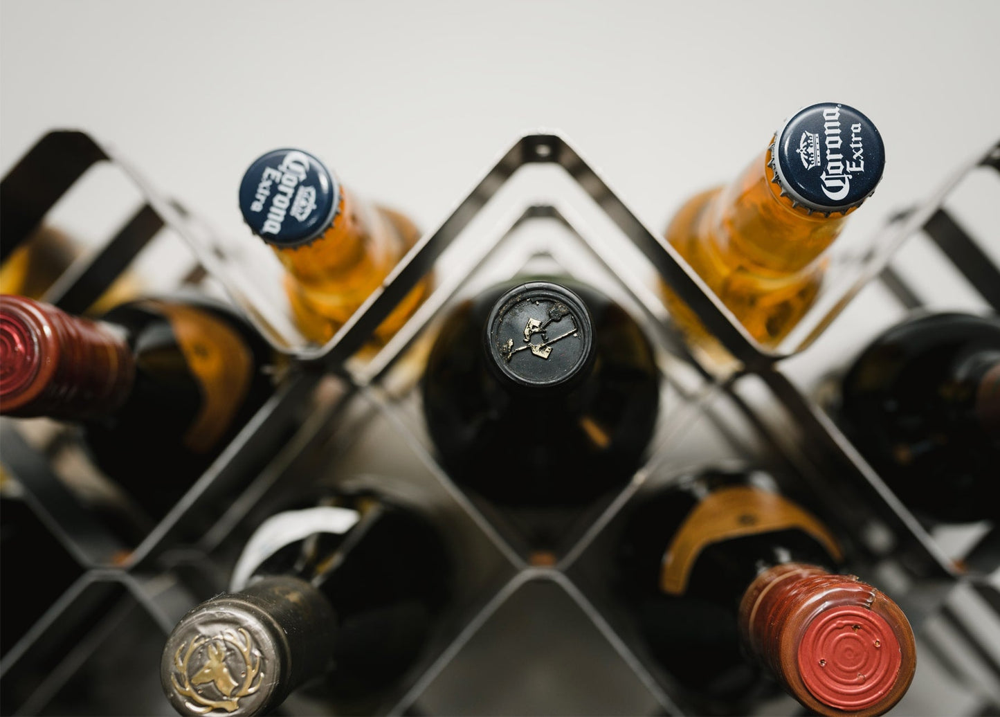 Wein- und Bierflaschenhälse mit Kronkorken und Wachssiegeln in einem Flaschenregal