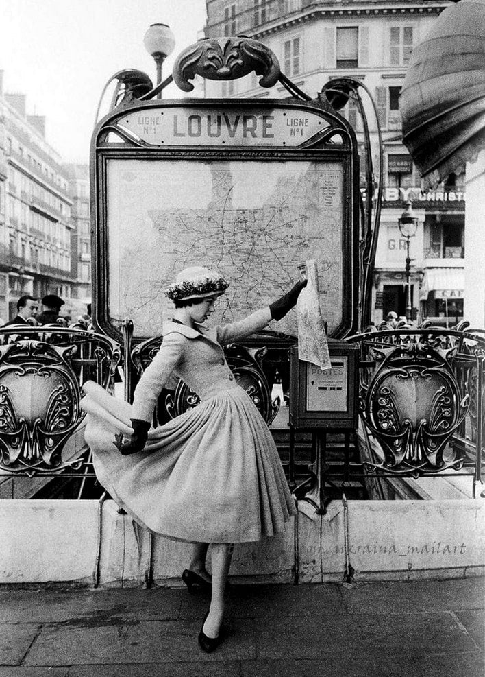 Woman in a full-skirted dress checking a map at the Louvre metro entrance in Paris