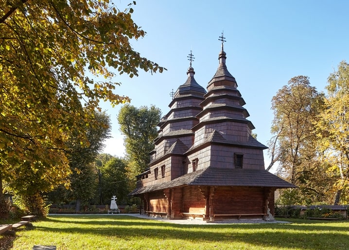 Дерев'яна церква з ярусними банями серед осіннього листя в Шевченківському гаю, Львів