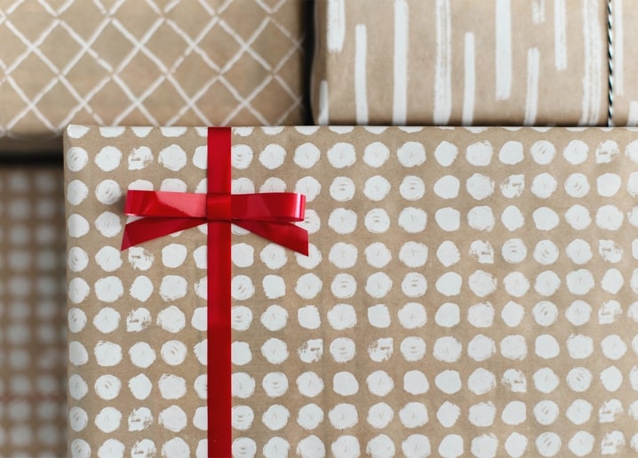 Packpapier mit Punktmuster, verschnürt mit einer roten Schleife