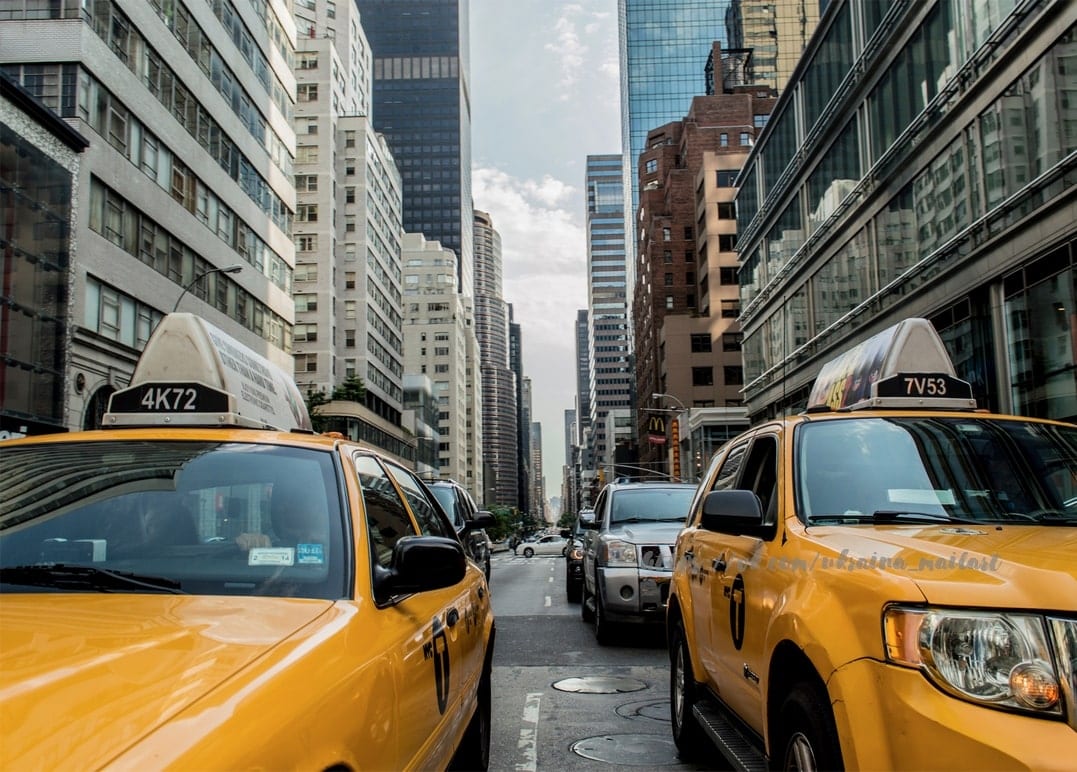 Жовті таксі в заторі серед скляних хмарочосів на вулиці Нью-Йорка