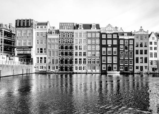 Black-and-white view of gabled canal houses reflected in an Amsterdam canal