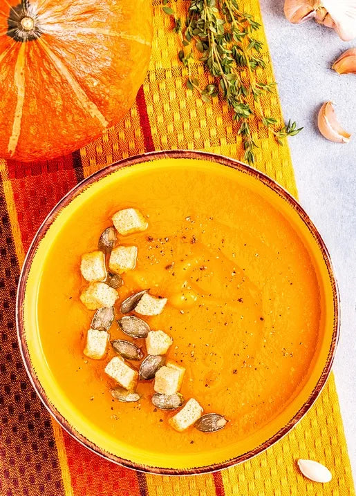 Autumn food postcard featuring creamy pumpkin soup topped with pumpkin seeds and golden croutons