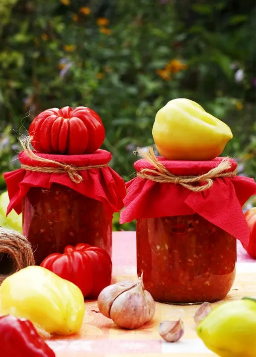 Harvest food postcard featuring jars of homemade tomato and pepper relish with fresh vegetables and garlic
