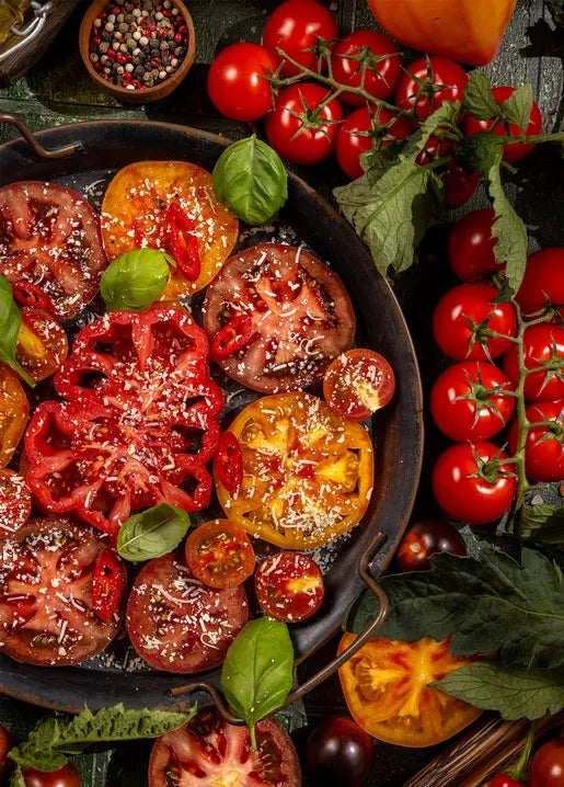 Food postcard featuring sliced heirloom tomatoes with fresh basil in a rustic dish