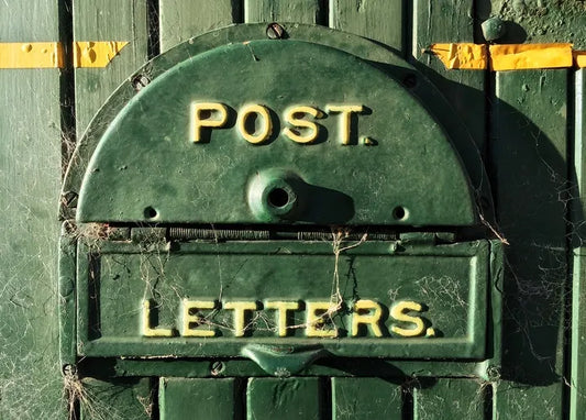Vintage photo postcard featuring an aged green metal letterbox marked POST and LETTERS