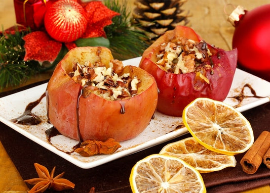 Baked apples stuffed with walnuts and chocolate, served with dried orange slices and cinnamon