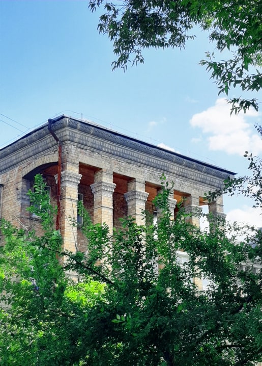 Classical stone portico with columns on a yellow-brick building, Bastionna Street, Kyiv