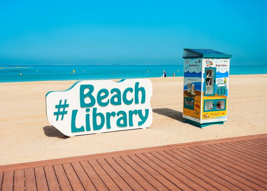 Türkisfarbener Strandbibliothek-Kiosk im weißen Sand am Meer