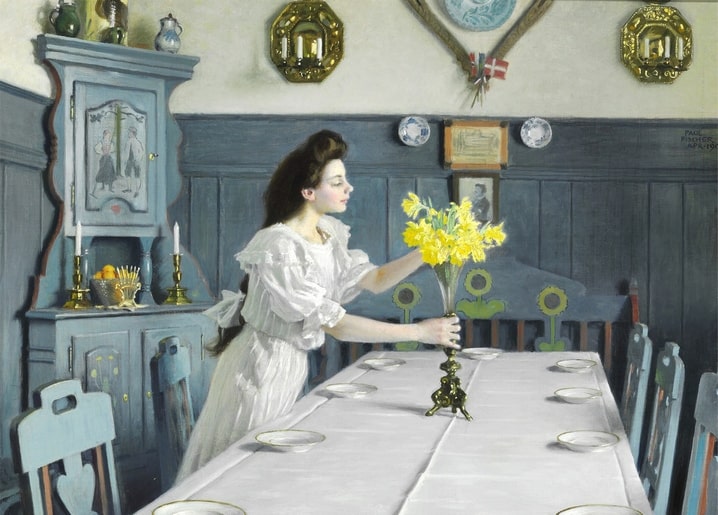 Gemälde einer Frau, die Narzissen auf einem zum Geburtstag gedeckten Tisch arrangiert