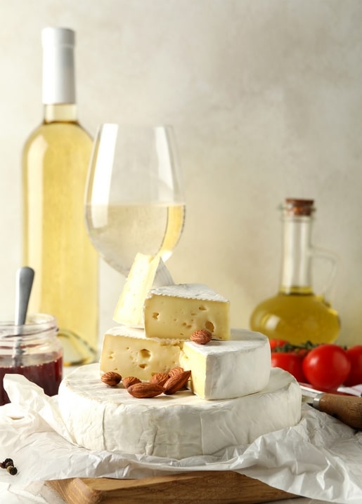 Brie-Käse mit Wein, Mandeln und Olivenöl auf einem herbstlichen Tisch