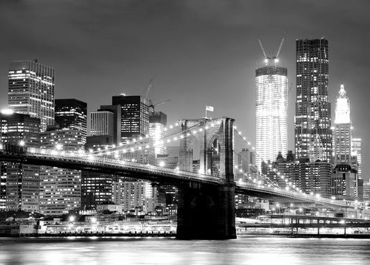 Brooklyn Bridge illuminated at night against the Manhattan skyline