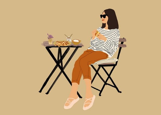 Illustration of a woman in sunglasses eating a croissant at a café table with coffee and lavender