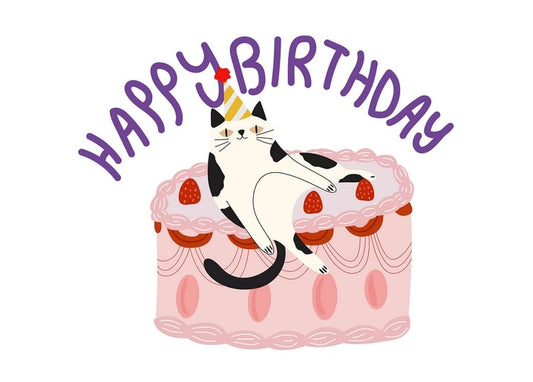 Чорно-білий кіт лежить на торті з полуницями під написом «Happy Birthday»